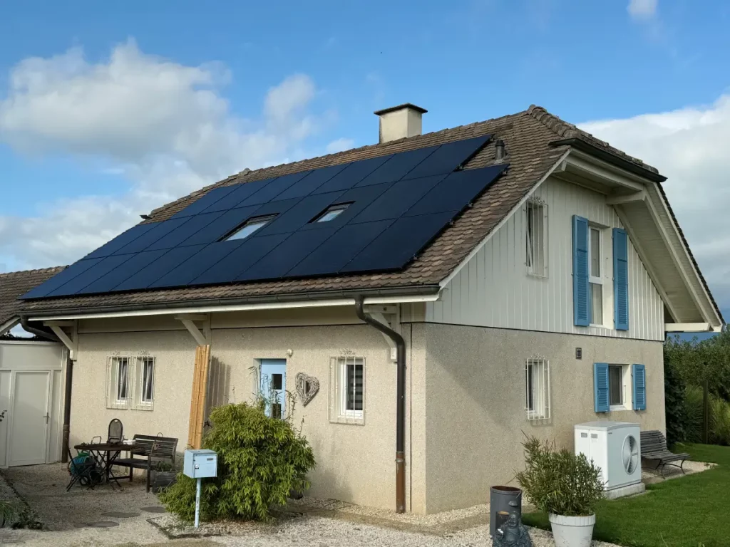 Maison familiale avec toiture en pente équipée de panneaux photovoltaïques sur toute la surface.